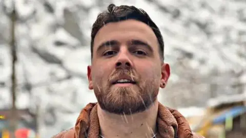 Erfan Soltani, 26, looks at the camera as snow falls.