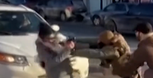 Screen grab showing a woman being pushed by an officer; Alex Pretti is at the far right moments before the takedown.