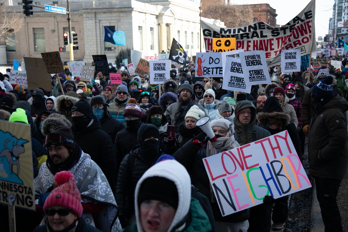 Crowd of demonstrators with signs at a protest shared on social media.