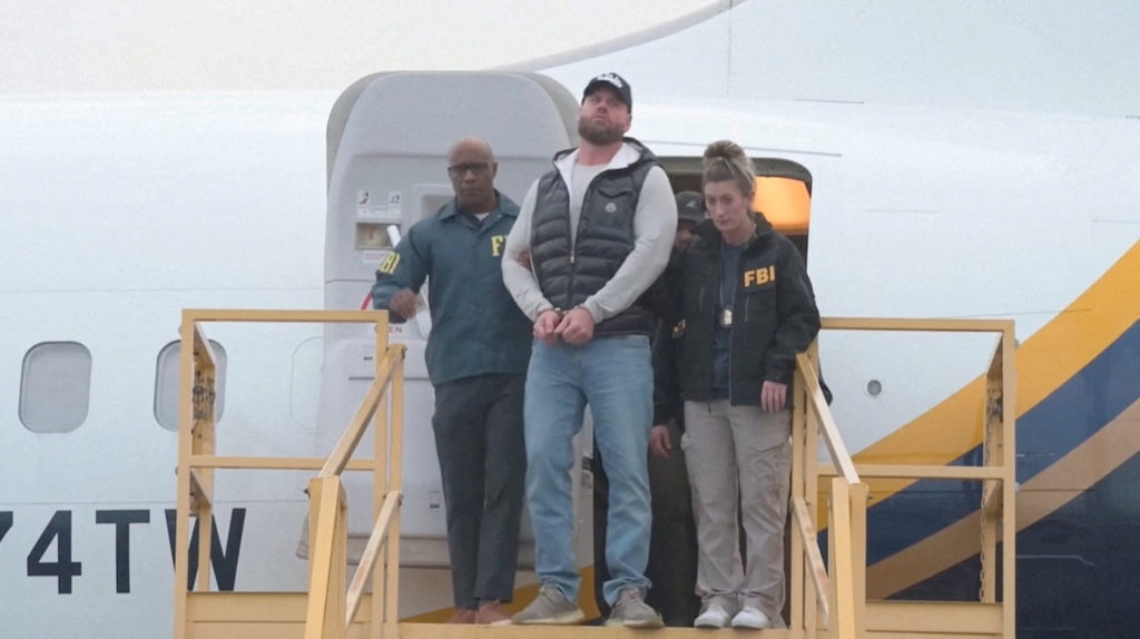 Ryan Wedding is escorted in handcuffs by FBI agents upon arrival at Ontario International Airport, California, Jan. 23, 2026. Image via FBI/Handout through Reuters.
