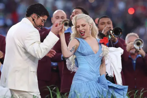Bad Bunny embraces Lady Gaga during the halftime performance