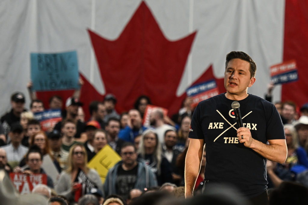 Canada-focused political rally with a speaker and Canadian flag, reflecting the U.S.-Canada tariff dispute at the center of the House vote.