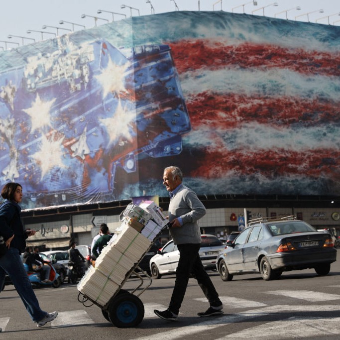 Left: People walk past an anti-U.S. billboard in Tehran, Iran, February 19, 2026. Photo by Majid Asgaripour/WANA (West Asia News Agency) via Reuters - Majid Asgaripour/WANA (West Asia News Agency) via Reuters