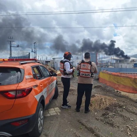 United Hatzalah paramedics observe smoke rising from near oil refineries in Haifa, northern Israel, after a salvo of missiles and drones launched by Iran and Hezbollah militants in Lebanon targeted northern Israel, March 30, 2026, amid ongoing U.S.-Israeli strikes on Iran. - Handout/United Hatzalah