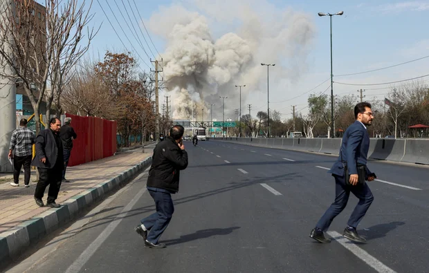 People run as smoke rises following an explosion in Tehran, Iran, March 5, 2026.