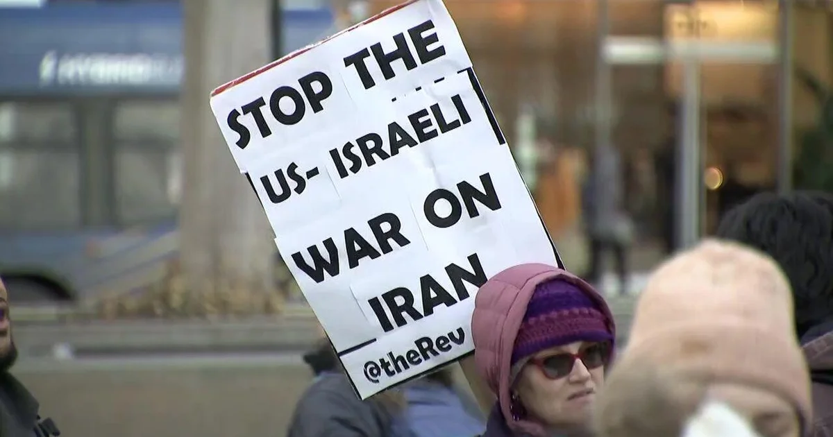 Protesters hold signs opposing war with Iran
