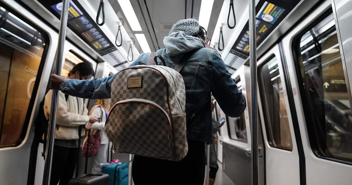 Traveler with a backpack moves through a crowded airport terminal during busy spring travel.
