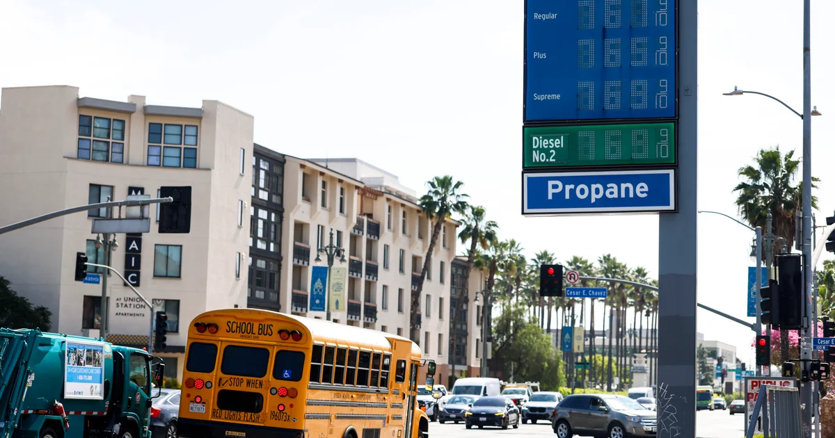 Fuel price sign above a busy street as gasoline costs climb nationwide.