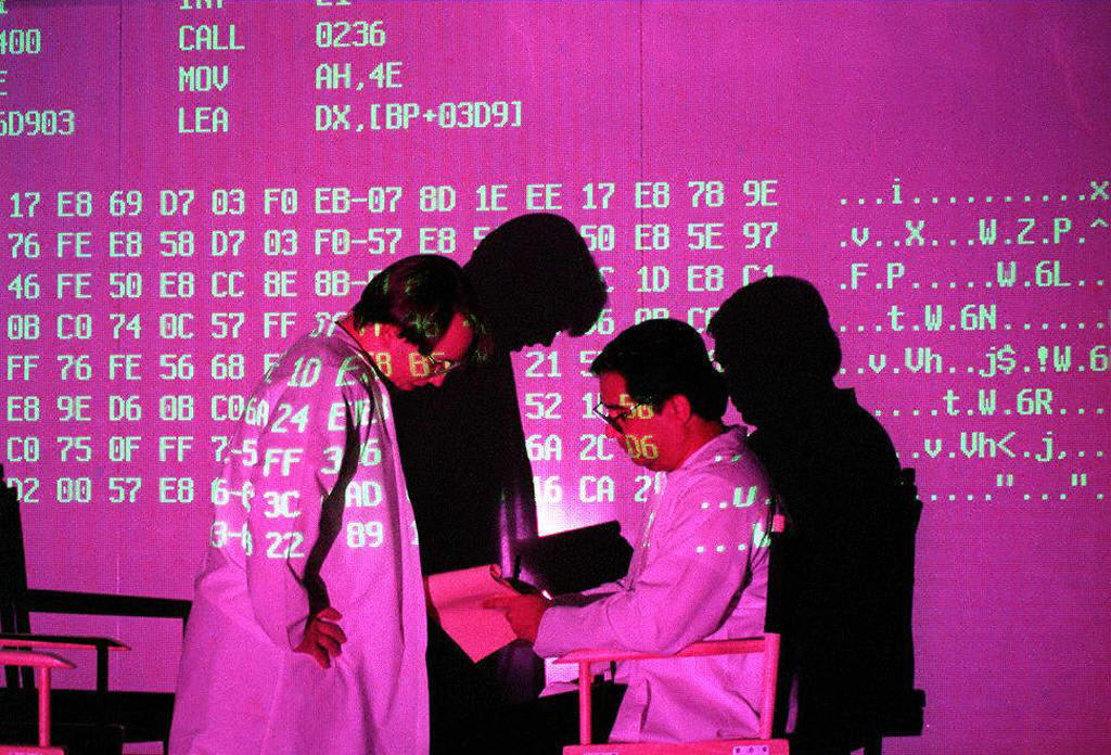 Analysts reviewing code on a large display, illustrating AI's role in defense and procurement operations
