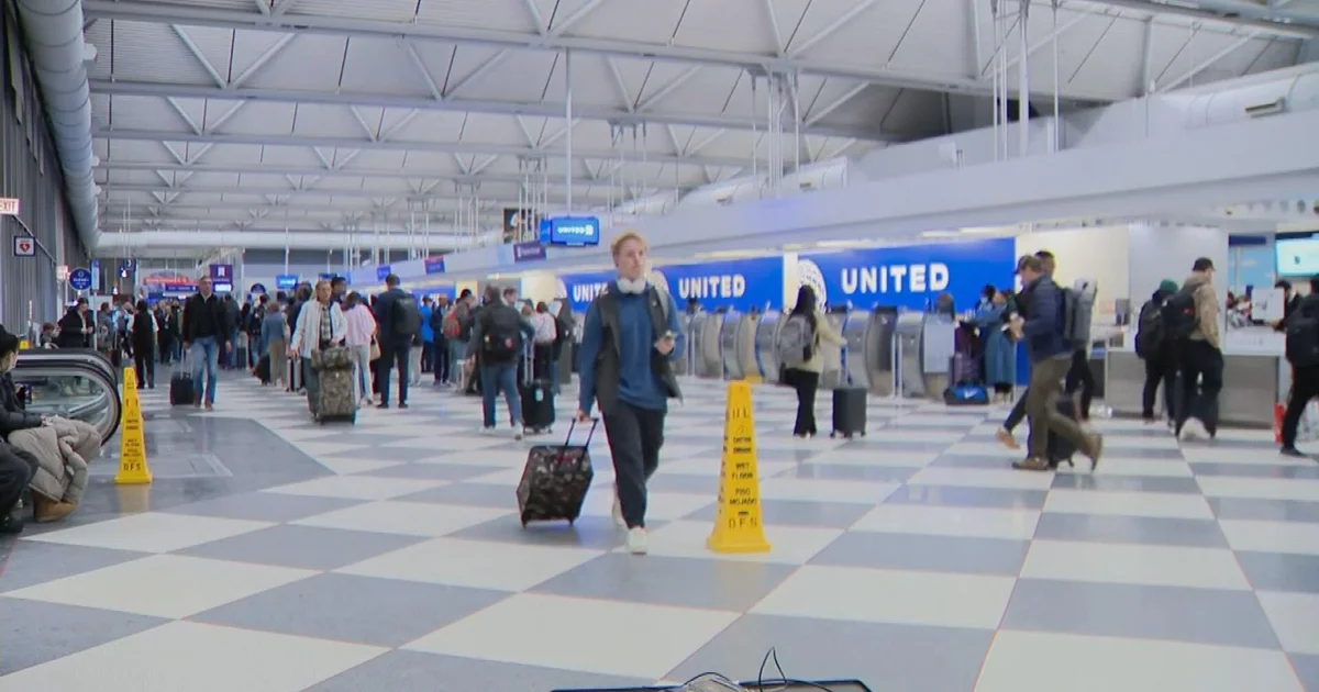 Passengers in a busy U.S. airport terminal with long lines at check-in amid the shutdown