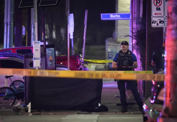 An Austin police officer guards a taped-off crime scene on West 6th Street following the shooting.