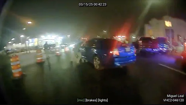 Bodycam still a moment after shots were fired, with an agent by the driver's window of Martinez's car.