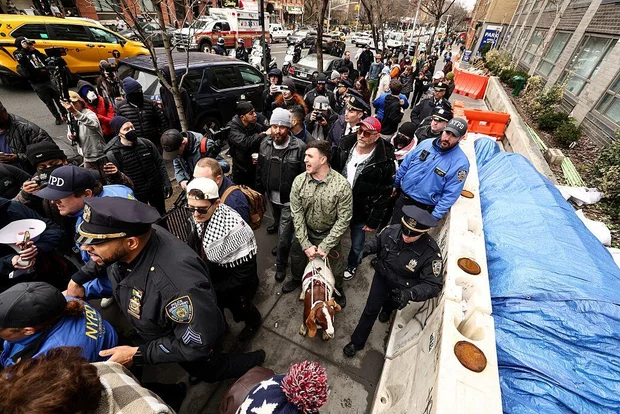 Far-right influencer Jake Lang holds a goat on a leash during a protest outside Gracie Mansion.